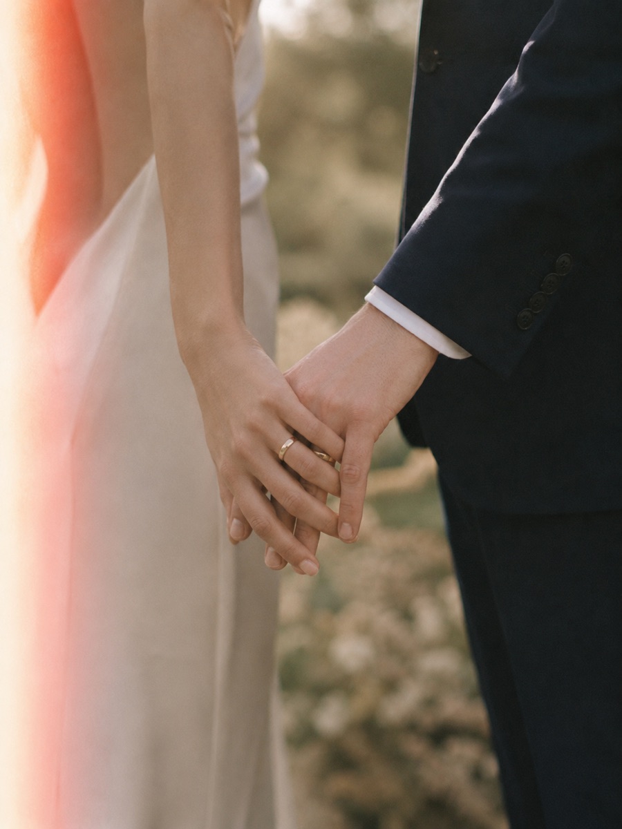 Las manos entrelazadas de los novios